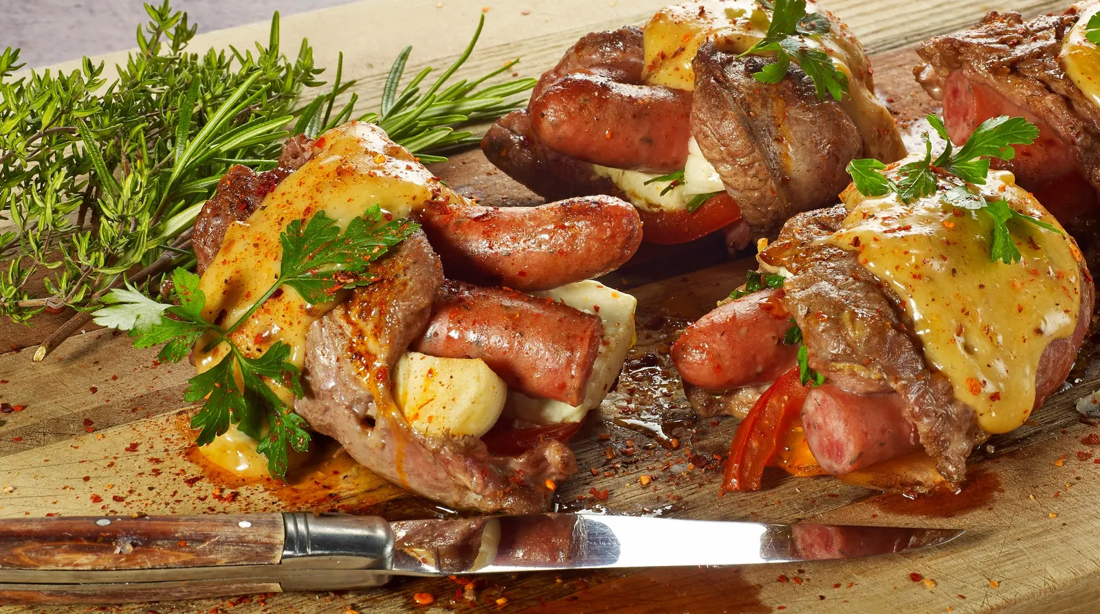 Grillat kött, korv och halloumi på skärbräda med rosmarin och timjan